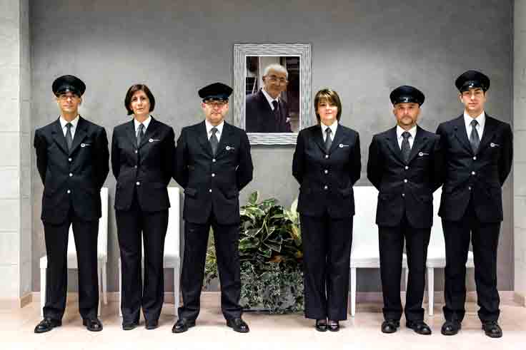Lo staff di Guala Centro Onoranze Funebri di fronte alla fotografia commemorativa di Mario Guala